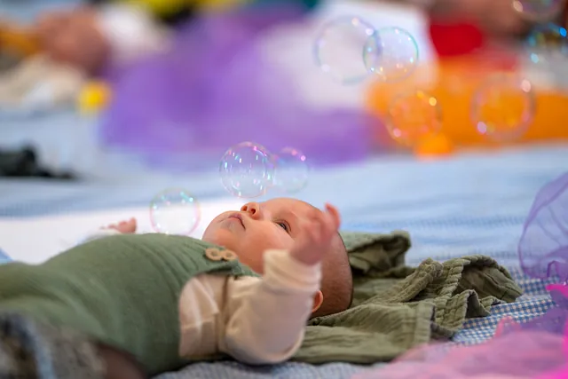 en baby der kigger på sæbebobler