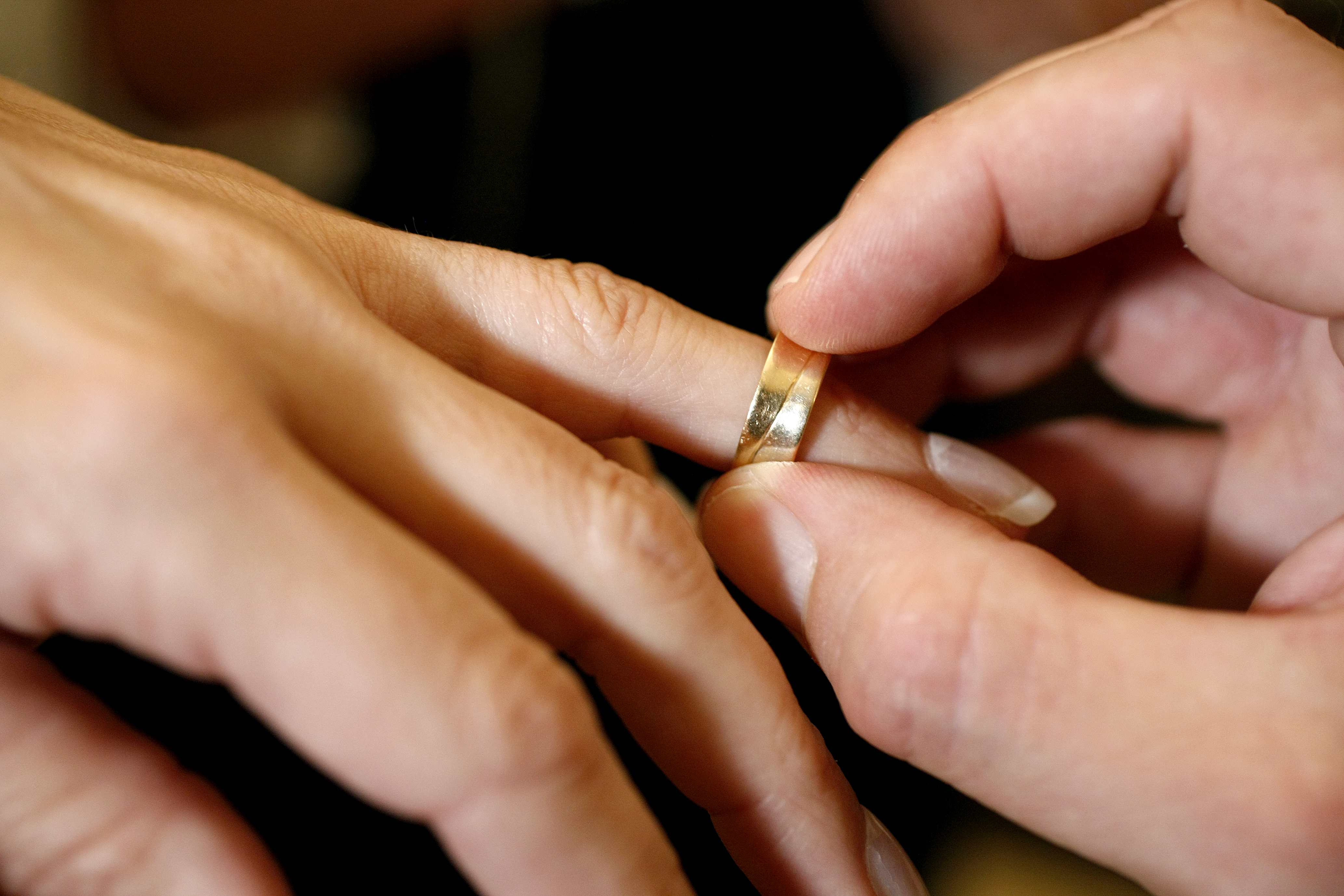 En ring bliver sat på en hånd til en vielse.