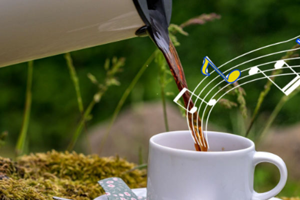 Kaffe bliver hældt i en kop, der kommer den dejligste musik ud af koppen. 